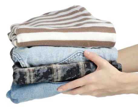 Hand holding stack of clothes jeans Stock Photos