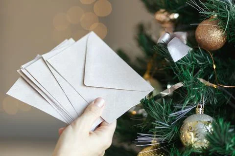 Hand holding stack of craft paper envelopes for christmas greeting card Foto stock