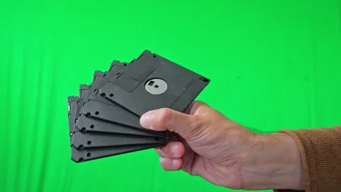 Hand Holding Stack of Floppy Disks on Green Screen Stock Footage 313913951