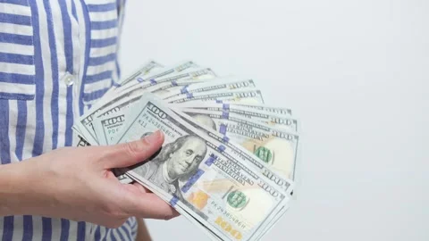 Hand holding stack of hundred dollar bills, showcasing wealth and financial Stock Footage 312307258