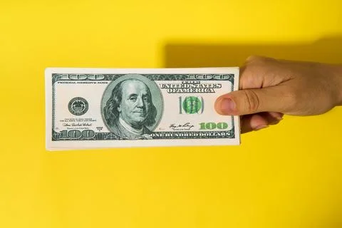 Hand holding stack of hundred dollar bills Stock Photos