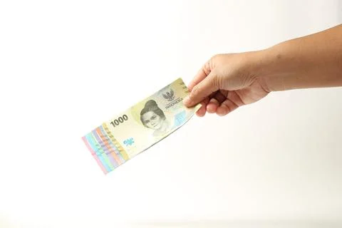 Hand Holding a Stack of Indonesian Rupiah Banknotes with 1000 IDR in Front Stock Photos