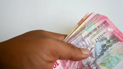 Hand Holding a Stack of Indonesian Rupiah One Hundred Thousand Banknotes Foto stock
