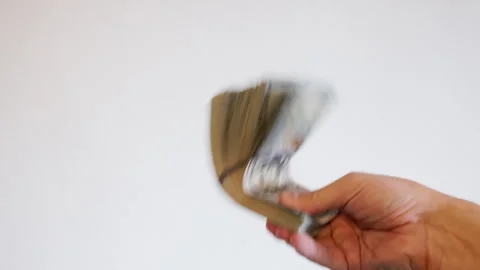 Hand holding stack of money in bright studio with white background Stock Footage 332027181
