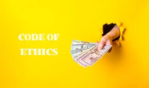 A hand holding a stack of money with the words Code of Ethics written below it Foto stock