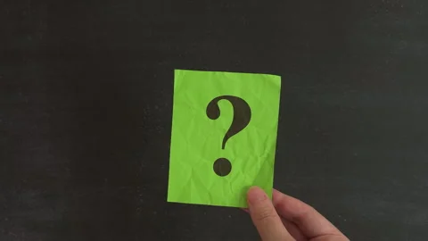 A hand holding a sticky note with a black question mark. Stock Footage 330311454