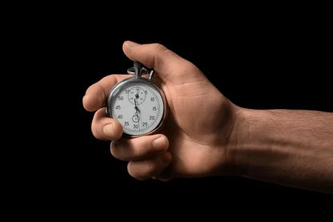 Hand holding a stopwatch on black background Stock Photos