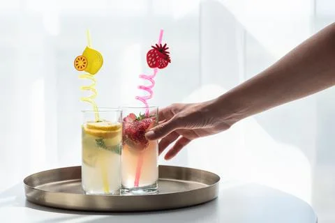 Hand holding strawberry drink from refreshing summer tray Stock Photos