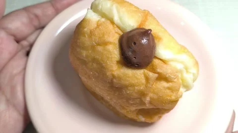 Hand Holding Sweet Mini Bun with Cream and Chocolate Stock Footage 321383573