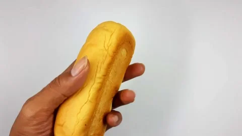 Hand holding a sweet yellow bread roll video footage Stock Footage 331069990