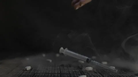 Hand holding syringe in dramatic lighting, representing healthcare Video stock 279315307