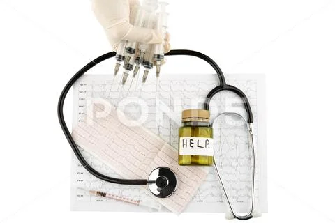 Hand holding syringes, stethoscope, bottle with pills and syringe on cardiogr Stock Photos