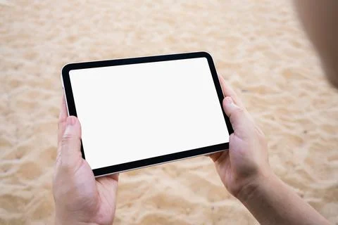 Hand holding tablet with blank screen at the beach for travel, summer vacat.. Stock Photos