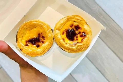 Hand Holding a Takeaway Box with Two Fresh Egg Tarts Stock Photos