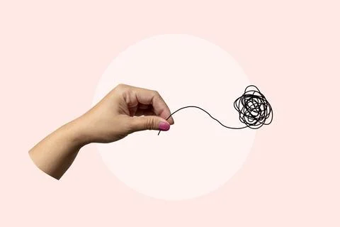 A hand holding a tangled piece of string Stock Photos