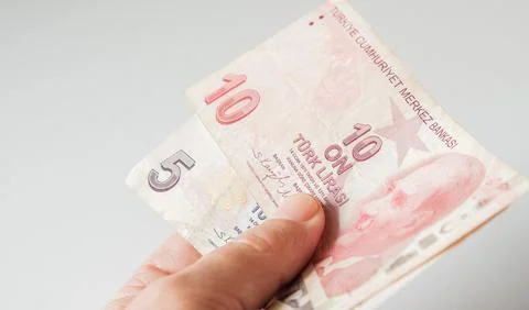 Hand holding ten and five Turkish Lira banknotes on a white background. Fotos Stock