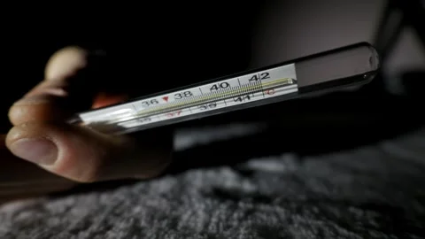 Hand Holding Thermometer With Dangerously High Fever Reading Stock Footage 325568943