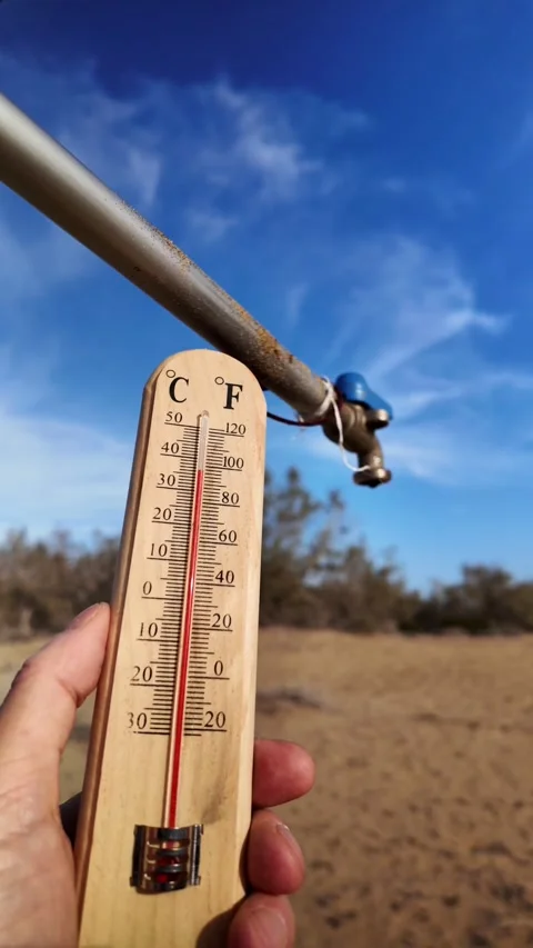 Hand holding thermometer measuring extreme heat during a drought Vídeos de archivo 329556476