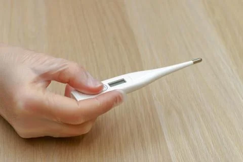 A hand holding a thermometer Stock Photos