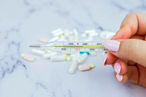 The hand holding the thermometer in which the elevated temperature. Medical t Stock Photos