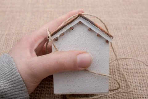 Hand holding a thread  around a model house Stock-Fotos