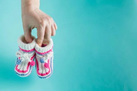 Hand holding tiny knitted booties Stock Photos