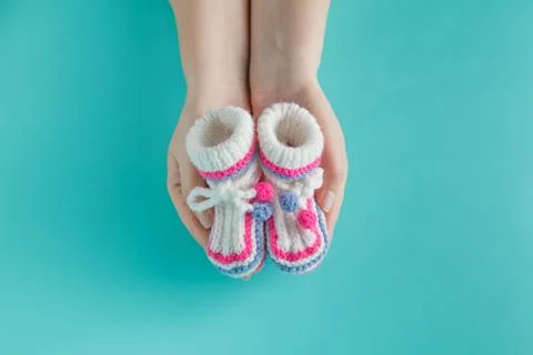 Hand holding tiny knitted booties Stock Photos