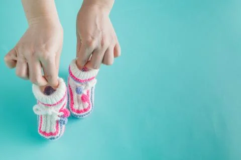 Hand holding tiny knitted booties Stock-Fotos
