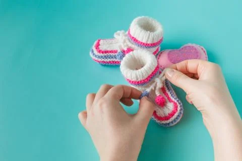 Hand holding tiny knitted booties Stock Photos