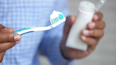 Hand holding tooth brush with paste Stock Footage 163349316