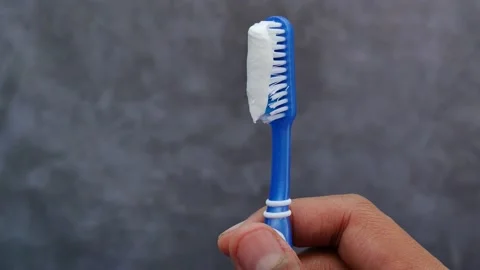 Hand holding tooth brush with paste Stock Footage 229484750