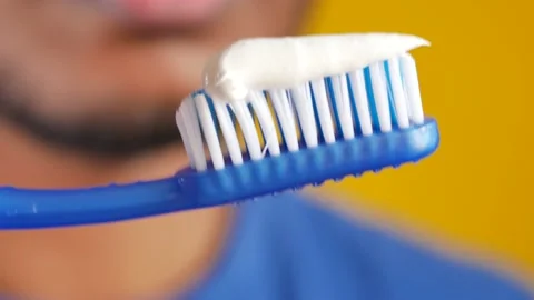 Hand holding tooth brush with paste Stock Footage 236794836