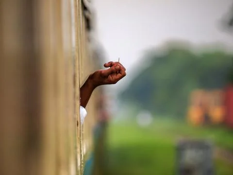 Hand holding a toothpick out of a train window in Myanmar, small everyday Stock Photos
