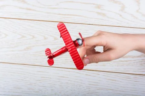 Hand holding a toy plane on wooden texture Stock Photos