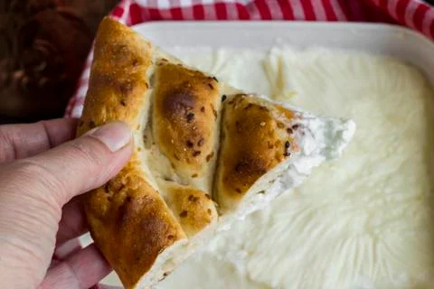Hand is holding triangle cut slice of Turkish Ramadan Bread Stock Photos
