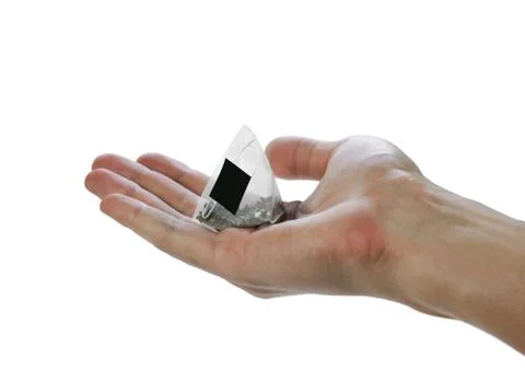 Hand holding a triangular tea bag. Close up. Isolated on white background Stock-Fotos