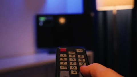 Hand holding the TV remote control and turn on smart tv. Switching channels. Stock Footage 332592402