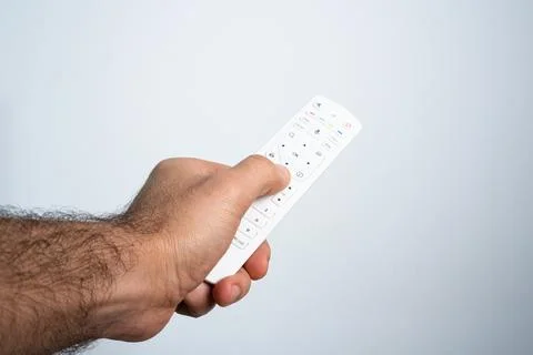 Hand holding TV remote control on neutral background Stock Photos