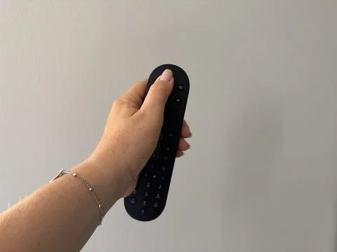 Hand holding a TV remote control Stock Photos