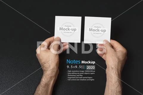 Hand holding two blank notes paper or image frame on dark background mock-up PSD-Vorlage