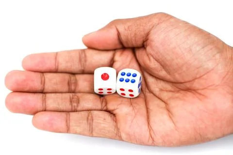 Hand Holding Two Dice With Red And Blue Dots Showing Numbers On A White Bac.. Stock Photos