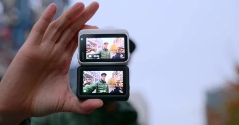 Hand holding two stacked action camera displaying vlogger face Stock Footage 339107458