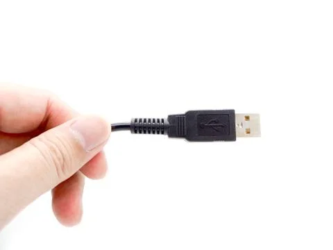 Hand holding USB cable isolated on a white background. Stock Photos
