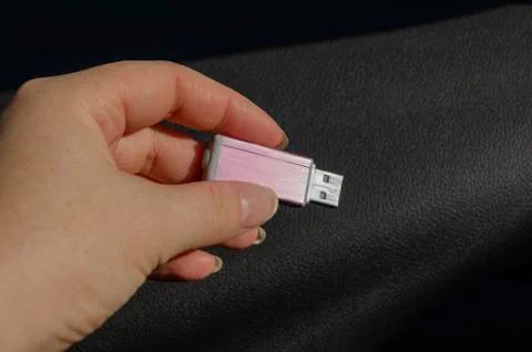 Hand holding USB device on dark background Stock Photos