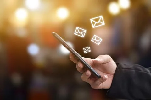Hand holding using mobile phone with email icon on screen. Concept of busines Stock Photos