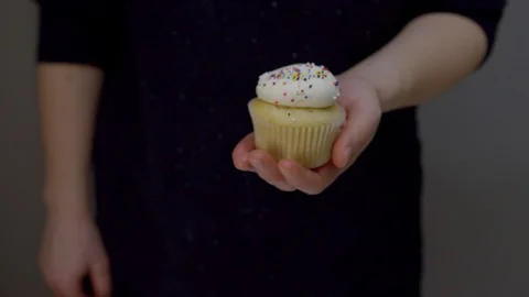 Hand Holding Vanilla Cupcake With Rainbow Sprinkles. 4K. Stock Footage 122017994