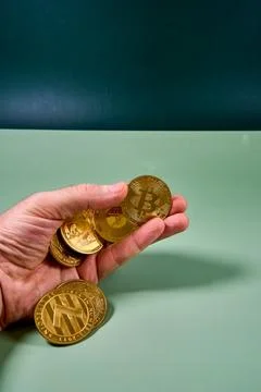 Hand holding various cryptocurrencies at table in studio Stock Photos