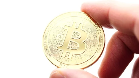 Hand holding a virtual bit-coin coin between his fingers. Stock Footage 124808673