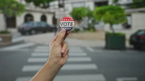 Hand holding vote button on urban street background, symbolizing election p.. Stock Footage 314291350