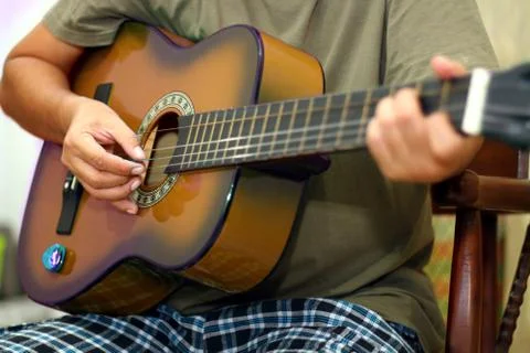 Hand  holding while playing acoustic guitar Stock Photos